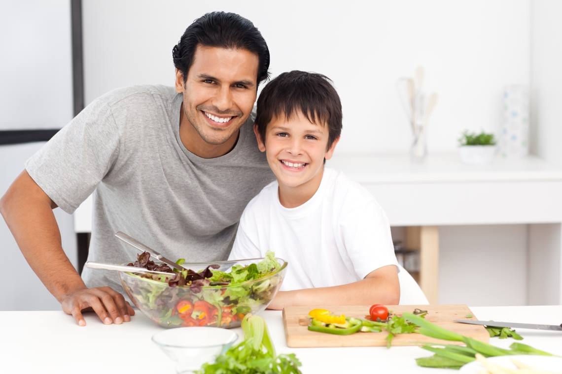 man with son cooking salad