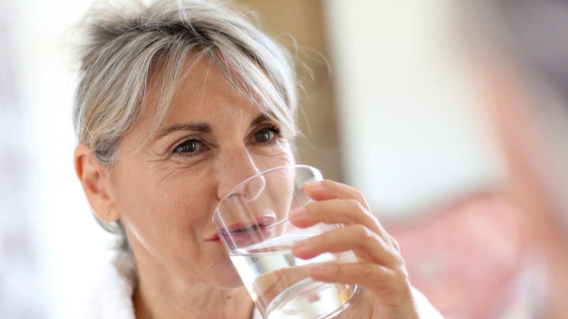 woman drinking a cup of water